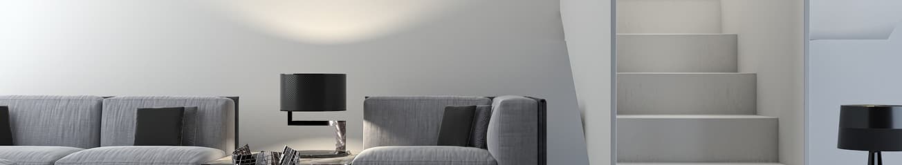 Sala minimalista con sofás grises, lámparas de mesa modernas y escaleras de diseño sencillo, creando un ambiente limpio y elegante.