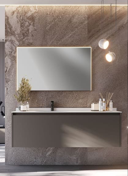 Baño elegante con lavabo flotante, espejo iluminado y detalles minimalistas, sobre un fondo de pared de piedra natural.