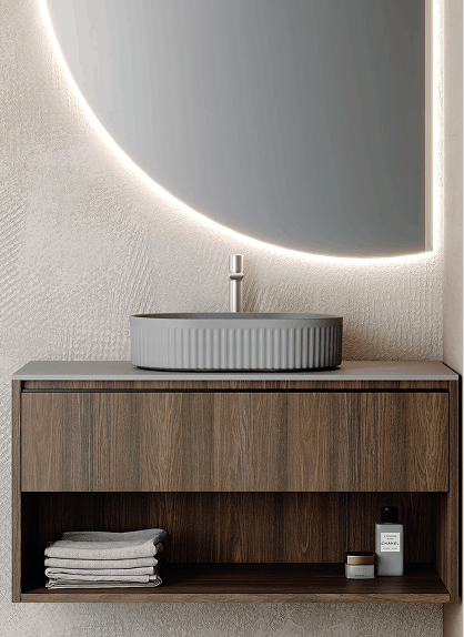 Lavabo moderno con un diseño minimalista, base de madera oscura y un espejo circular iluminado que aporta una atmósfera sofisticada y elegante al baño.